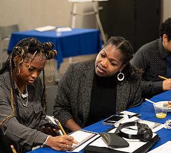 Students and mentors working on their investments.